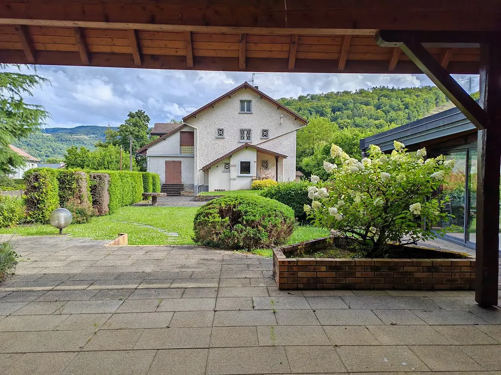 Vue réelle depuis la terrasse couverte du pavillon vers le jardin et la maison principale